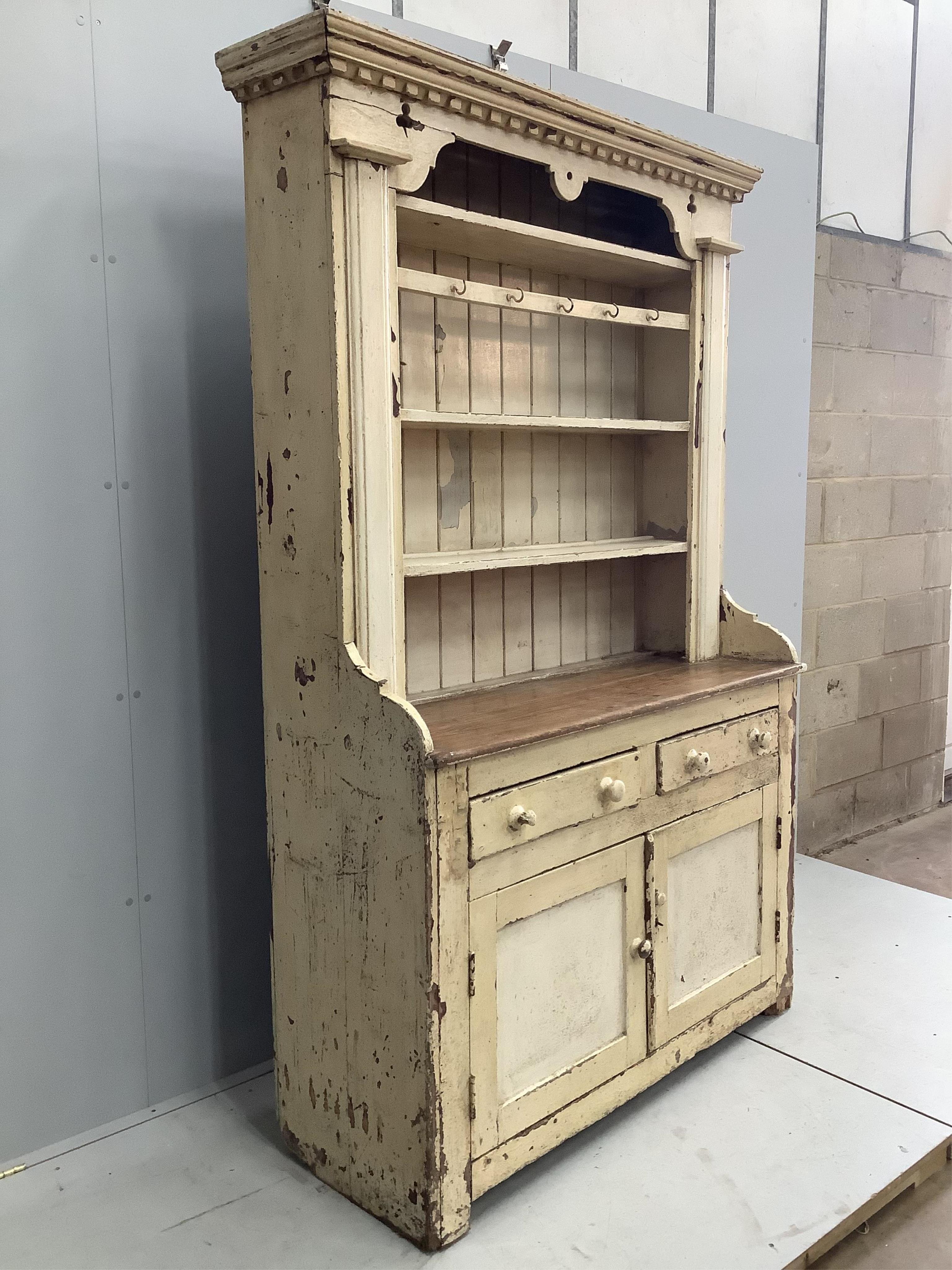 An early 19th century Irish painted pine dresser with boarded rack, width 126cm, depth 49cm, height 210cm. Condition - fair